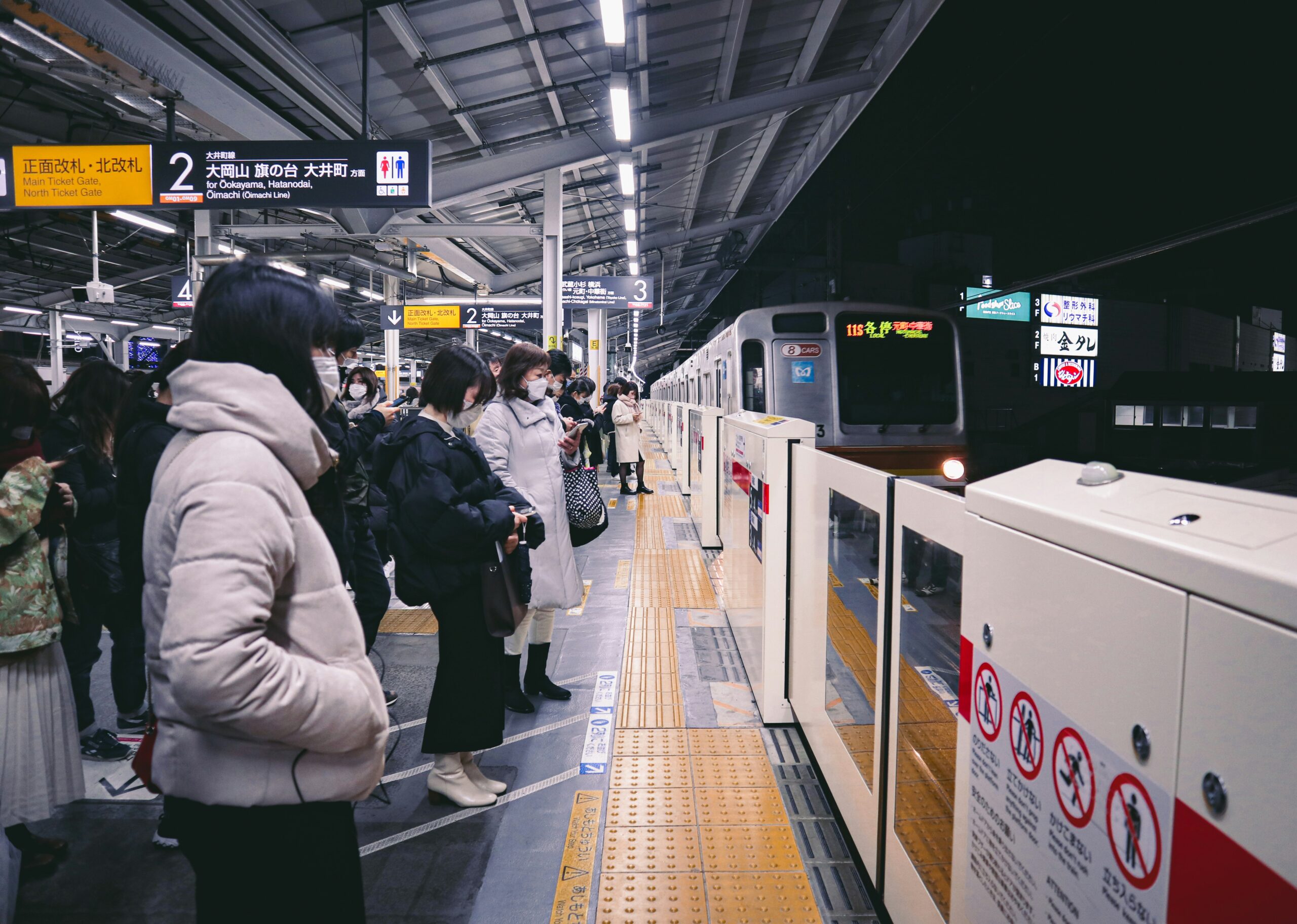Commuters waiting at a Japanese train station, illustrating consumer behavior insights vital for digital marketing strategies in Japan